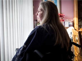 Andrea Lavoie sits in a wheelchair in the living room of her house in Dollard-des-Ormeaux on on Friday, February 12, 2016. After a spinal tumour that left her a paraplegic, she now finds herself in a home that has no adaptation for an individual with reduced mobility. The government program that helps with home adaptation has kept her waiting almost two years for a stair-chair that would allow her to use the second floor of her house. (Giovanni Capriotti / MONTREAL GAZETTE)