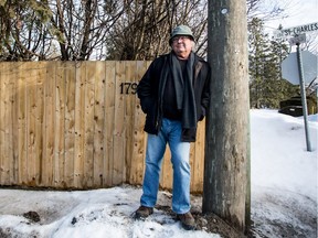 Hudson resident Trevor Smith stands by the fence around his property on Sunday February 21, 2016, in Hudson, Quebec. As a result of a dispute about the fence he sued the town. (Giovanni Capriotti / MONTREAL GAZETTE)
