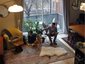 Renaud Shareck with his dog Miro, a Shiba Inew from Japan, in the living room of his  two-storey condo. It is cozy and new, built in 2011. Renaud is 30 years old and loves mid-century furniture.  (Marie-France Coallier / MONTREAL GAZETTE)