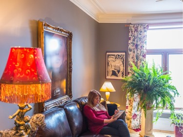 Johanne Giguere reads her iPad in the living room of her home in the Plateau-Mont-Royal. (Dario Ayala / Montreal Gazette)