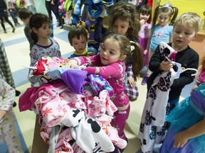 Chloe Elman, 4 1/2, surrounded by classmates at Garderie Foundation School of Congregation Shaar Hashomayim, puts a pair of pyjamas into a box at a Wear a Pyjama/Give a Pyjama day in support of Auberge Shalom.