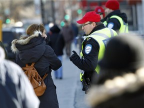Montreal police held a pedestrian safety workshop on Tuesday at the corner of Côte-des-Neiges Rd. and Jean-Brillant St. following three deadly collisions so far in 2016. Sgt Yves Landry, right, tells a pedestrian what the rules are on Feb. 2, 2016.