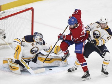 Montreal Canadiens Alex Galchenyuk can't get his stick on the puck as he's checked by Buffalo Sabres Johan Larsson, right, in front of goalie Robin Lehner during first period of National Hockey League game in Montreal Wednesday February 3, 2016.
