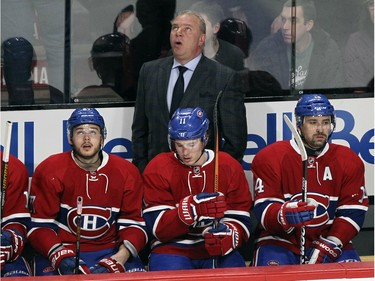 Montreal Canadiens coach Michel Therrien looks up at replay behind players Alex Galchenyuk, left, Brendan Gallagher and Tomas Plekanec  during first period of National Hockey League game against the Buffalo Sabres in Montreal Wednesday February 3, 2016.