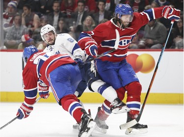 Montreal Canadiens defencemen Alexei Emelin, left, and Tom Gilbert sandwich Tampa Bay Lightning Nikita Kucherov during second period of National Hockey League game in Montreal Tuesday February 9, 2016.