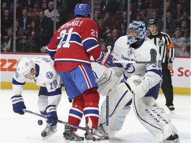 Montreal Canadiens Devante Smith-Pelly screens Tampa Bay Lightning goalie Ben Bishop as shot hits Ondrej Palat, left, during first period of National Hockey League game in Montreal Tuesday February 9, 2016.