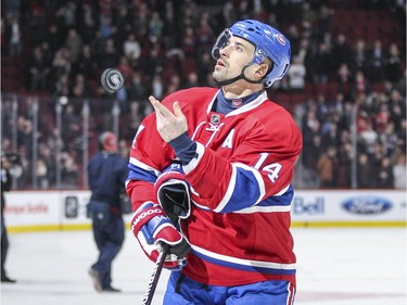 Montreal Canadiens Tomas Plekanec tosses a puck into the stands after being named first star of the game against the Tampa Bay Lightning in National Hockey League game in Montreal Tuesday February 9, 2016.