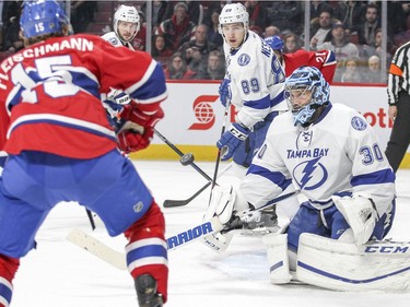 Tampa Bay Lightning goalie Ben Bishop bats the puck away from Montreal Canadiens Tomas Fleischmann as Lightning Nikita Nesterov, 89, and Nikita Kucherov watch during third period of National Hockey League game in Montreal Tuesday February 9, 2016.