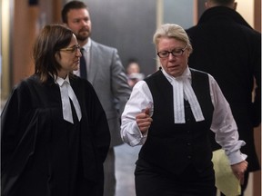 MONTREAL, QUE.: FEBRUARY 12, 2016 -- Crown lawyers Johanne Duplessis and Genevieve Dagenais, right, and Det-Sgt Frederic Gagn, in the background, in the Palais de Justice hallway in Montreal, on Friday, February 12, 2016 during a break in the case where Idelson Guerrier is charged with murdering two people and attempting to murder two others at a hospital in Montreal.