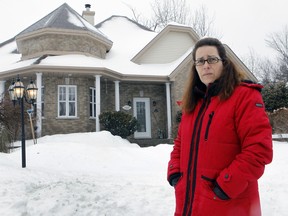 Celine Benssoussen stands in front of her  St-Lazare home on Tuesday February 16, 2016. She is one of a growing list of St-Lazare homeowners whose foundations are sinking. Her house has developed cracks in its foundation due to this and she will have to spend $70,000 for needed repairs. She and others are asking the local government to help out with financing the work on February 15, 2016. (Marie-France Coallier / MONTREAL GAZETTE)