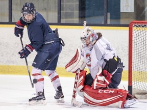 Marie-Philip Poulin deflects a shot in front of goalie Charline Labonté during Canadiennes practice at Étienne-Desmarteau Arena in Montreal on Feb. 16, 2016.