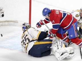Canadiens' Brendan Gallagher falls over Nashville Predators goalie Pekka Rinne after scoring a goal despite check by defenceman Shea Weber, right, during first period of National Hockey League game in Montreal Monday February 22, 2016.