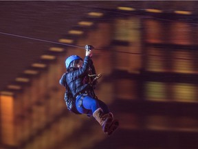 A woman uses the zip line attraction installed for the Montreal en Lumiere festival at Place des Arts in Montreal, Feb. 25, 2016.