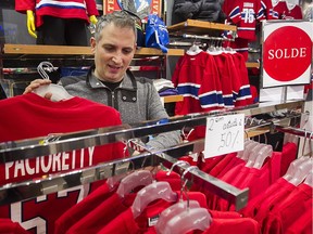 Clothing store owner Tamer Amhaz tries to promote his Montreal Canadiens sweaters  on display at his store in downtown Montreal on Thursday Feb. 4, 2016.