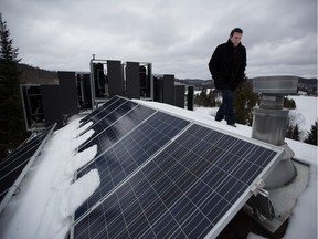Stephane Mercier, president of O2 Global Energy, poses with an installation of combination wind turbines and solar panels on a home in St-Adolphe-d'Howard, north of Montreal, on Thursday, February 4, 2016.  (Allen McInnis / MONTREAL GAZETTE)