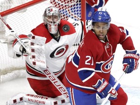 Devante Smith-Pelly of the Montreal Canadiens and goalie Cam Ward of the Carolina Hurricanes keep watch on a puck in the third period of an NHL game at the Bell Centre in Montreal on Sunday, Feb. 7, 2016.