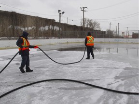 Blue collar workers water a hockey rink at Duff Court park in the Lachine borough of Montreal Tuesday, Feb. 9, 2016.
