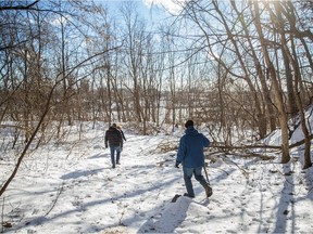 John Symon, right, supporter of Sauvons la falaise, walks through the Falaise St-Jacques escarpment which sits adjacent to the Turcot yard in Montreal on Monday, January 11, 2016.