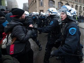 Protesters clash with SPVM police during the annual demonstration against police brutality in downtown Montreal on Friday, March 15, 2013.