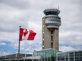 A view of a Canadian flag and the control tower at Pierre Elliott Trudeau International Airport in Montreal on Wednesday, May 20, 2015.