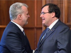 Premier Philippe Couillard has given Employment and Social Solidarity Minister François Blais (right) the mandate to study minimum income as a possible model for Quebec.