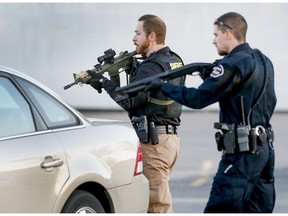 Police look for a possible second shooter in the parking lot of  Excel Industries in Hesston, Kan., Thursday, Feb. 25, 2016, where a gunman killed an undetermined number of people and injured many more.