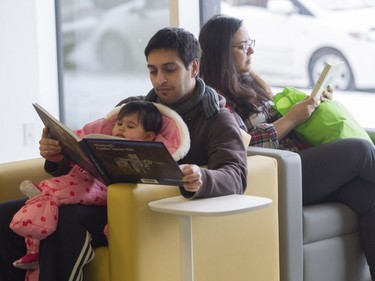 Richard Moush reads with his daughter Siana at the N.D.G. Cultural Centre and Benny Library in Montreal on Saturday, Feb. 6, 2016, at an open house.