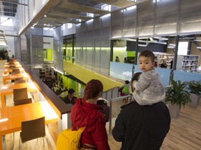 Ève François and her parents Tanis Keiner and Floran François look around the N.D.G. Cultural Centre and Benny Library in Montreal on Saturday, Feb. 6, 2016, at an open house event. The doors will open officially Tuesday.