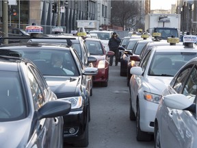 Taxi drivers wait in front of the courthouse as representatives deposit a request for an injunction against the ride sharing company Uber Feb. 2, 2016 in Montreal.