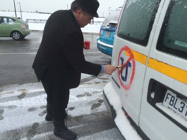 A driver paints an anti-Uber symbol on the back of van during a Montreal-wide protest Feb. 10, 2016.