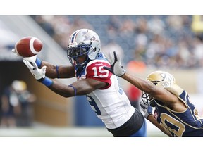 Montreal Alouettes' S.J. Green (19) can't hang onto the pass from quarterback Rakeem Cato (12) during the first half of CFL action against Johnny Adams (20) and the Winnipeg Blue Bombers in Winnipeg Friday, July 10, 2015.