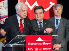 Federal Immigration Minister John McCallum, left, with Montreal Mayor Denis Coderre and Yvan Gauthier, announces funding on Wednesday for organizations supporting Syrian refugees.