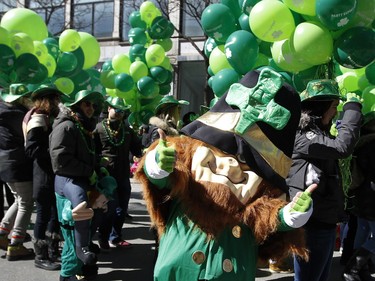 A leprechaun dances his way along Ste-Catherine St. during the annual St. Patrick's Parade in Montreal on Sunday, March 20, 2016.