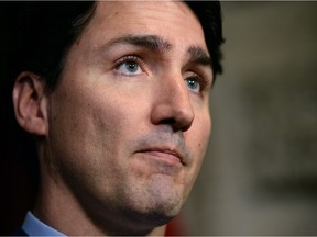 Prime Minister Justin Trudeau pauses as he responds to the deadly attacks in Brussels as he speaks in the foyer of the House of Commons on Parliament Hill in Ottawa on Tuesday, March 22, 2016.
