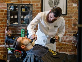 Waxman House barber Chris Pilozzi applies shaving cream to client and shoe designer Jordan Pascal at the Montreal clothing store and barber shop. The hip, vintage vibe offers men a place to relax and unwind.