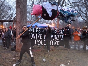 A man hits a pinata during a rally against police brutality in Montreal on Tuesday, March 15, 2016. The protest has been held in Montreal for nearly 20 years.
