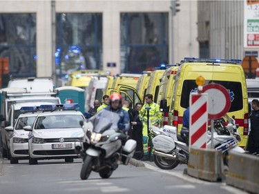 A police motorcycle rides by ambulances at a staging station near a metro after an explosion in Brussels on Tuesday, March 22, 2016. Explosions, at least one likely caused by a suicide bomber, rocked the Brussels airport and subway system Tuesday, prompting a lockdown of the Belgian capital and heightened security across Europe. At least 26 people were reported dead.