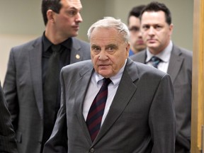 Coroner Cyrille Delage, right, and police investigator Andre Roussy, left, walk out of the courtroom for lunch break, at the beginning of a coroner's inquest on the L'Isle-Verte fire tragedy, Monday, November 17, 2014 in Riviere-du-Loup, Que.