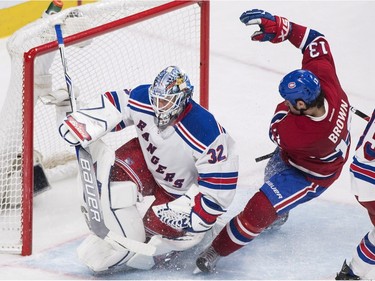 Montreal Canadiens' Mike Brown (13) slides in on New York Rangers goaltender Antti Raanta during third period NHL hockey action in Montreal, Saturday, March 26, 2016.