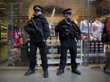 Armed British police officers stand guard after Eurostar services were suspended on the Brussels route because of the attacks in Belgium, at St Pancras international railway station in London, Tuesday, March 22, 2016. Authorities in Europe and beyond have tightened security at airports, on subways, at the borders and on city streets after deadly attacks Tuesday on the Brussels airport and its subway system.