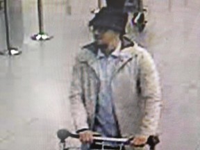 A handout image released on March 22, 2016 by the Belgian Federal Police on demand of the Federal prosecutor shows a screengrab of the airport CCTV camera showing a suspect of the attacks at Brussels Airport, in Zaventem, pushing a trolly with suitcases