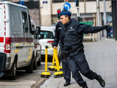 Police officers run towards Maalbeek metro station in Brussels on March 22, 2016 after a series of apparently coordinated explosions ripped through Brussels airport and a metro train, killing at least 14 people in the airport and 20 people in the metro in the latest attacks to target Europe.