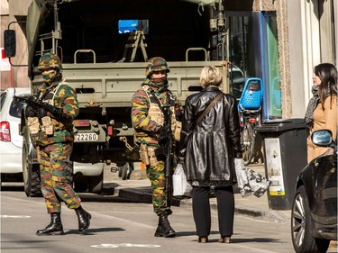 Women speak to soldiers as they block the access to road close to Maalbeek metro station in Brussels on March 22, 2016 after a series of apparently coordinated explosions ripped through Brussels airport and a metro train, killing at least 14 people in the airport and 20 people in the metro in the latest attacks to target Europe.