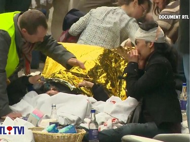 This image grab made on March 22, 2016 from video by RTL TV shows wounded people receiving assistance by rescuers outside the Maalbeek metro station in Brussels on March 22, 2016 after a blast at this station located near the EU institutions.