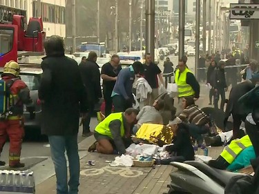 This image grab made on March 22, 2016 from a video by RTL TV shows wounded people receiving assistance by rescuers outside the Maalbeek metro station in Brussels on March 22, 2016 after a blast at this station located near the EU institutions.
