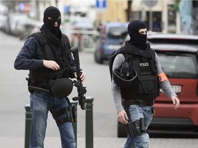 Police officers walk at the site of a shooting in the southern Forest district of Brussels on March 15, 2016.  Shots were fired at Belgian police in the capital Brussels as they carried out an operation linked to the Paris attacks, Belgian prosecutors told AFP. The raid comes as Belgian police continue their hunt for Salah Abdeslam -- a key suspect in the November attacks which killed 130 people -- who comes from Brussels.