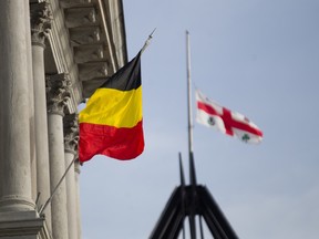 The Belgian flag flies from Montreal city hall as a Montreal flag flies at half staff in the background in tribute to Belgium, Tuesday March 22, 2016, following attacks in Brussels that have killed a reported 31 people.