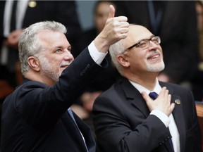 Quebec Premier Philippe Couillard, left, gives the thumbs up while standing with Finance Minister Carlos Leitão, before presenting the provincial budget, Thursday, March 26, 2015 at the legislature in Quebec City.