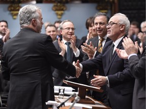 Quebec Finance Minister Carlos Leitao, right, is congratulated by Quebec Premier Philippe Couillard, left, at the end of his budget speech, Thursday, March 17, 2016 at the Quebec Legislature.