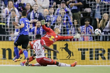 New York Red Bulls goalkeeper Luis Robles reaches for the ball as Montreal Impact forward Lucas Ontivero, left, misses a shot during the first half of the Impact's home opening match at the Olympic Stadium in Montreal on Saturday, March 12, 2016.